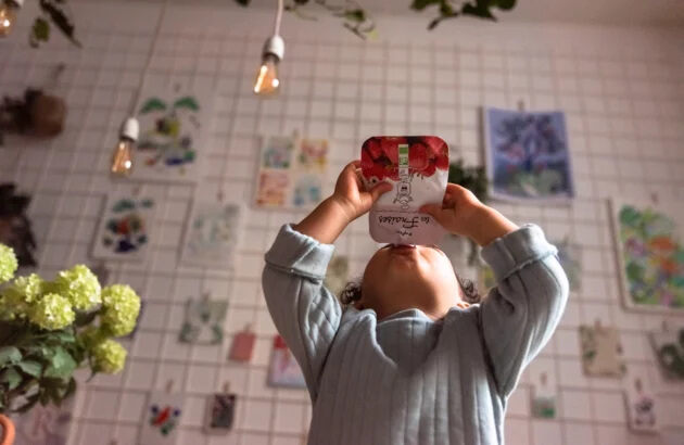 Enfant avec une gourde de fruits Popote