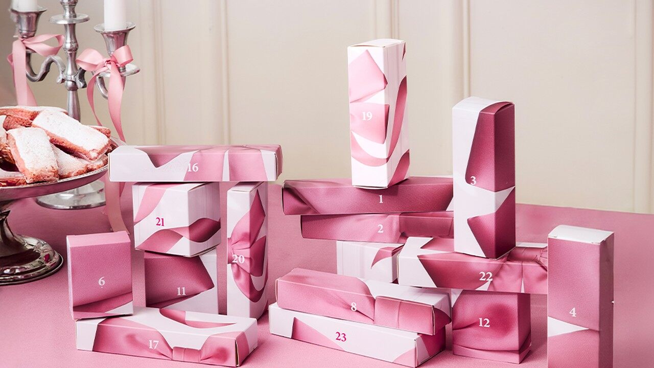 Les 24 boîtes roses numérotées du calendrier de l’Avent Bourjois 2026 sur une table de fête