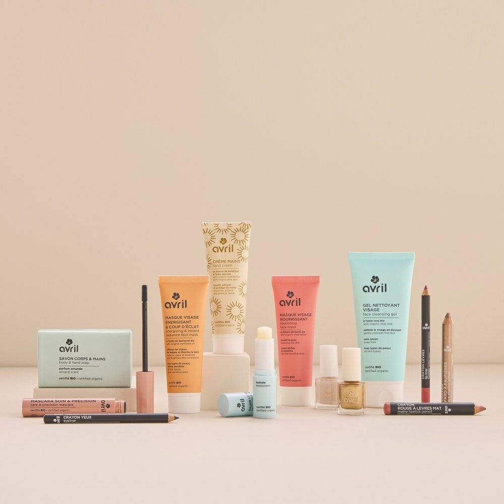 Les 24 produits du calendrier Avril 2026 : gels douche, masques visage, crayons, vernis, baume et accessoires, devant le coffret