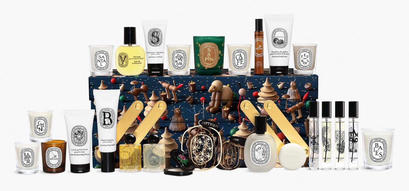 Le calendrier de l’Avent Diptyque 2026 ouvert, entouré de ses bougies, eaux de parfum et soins parfumés