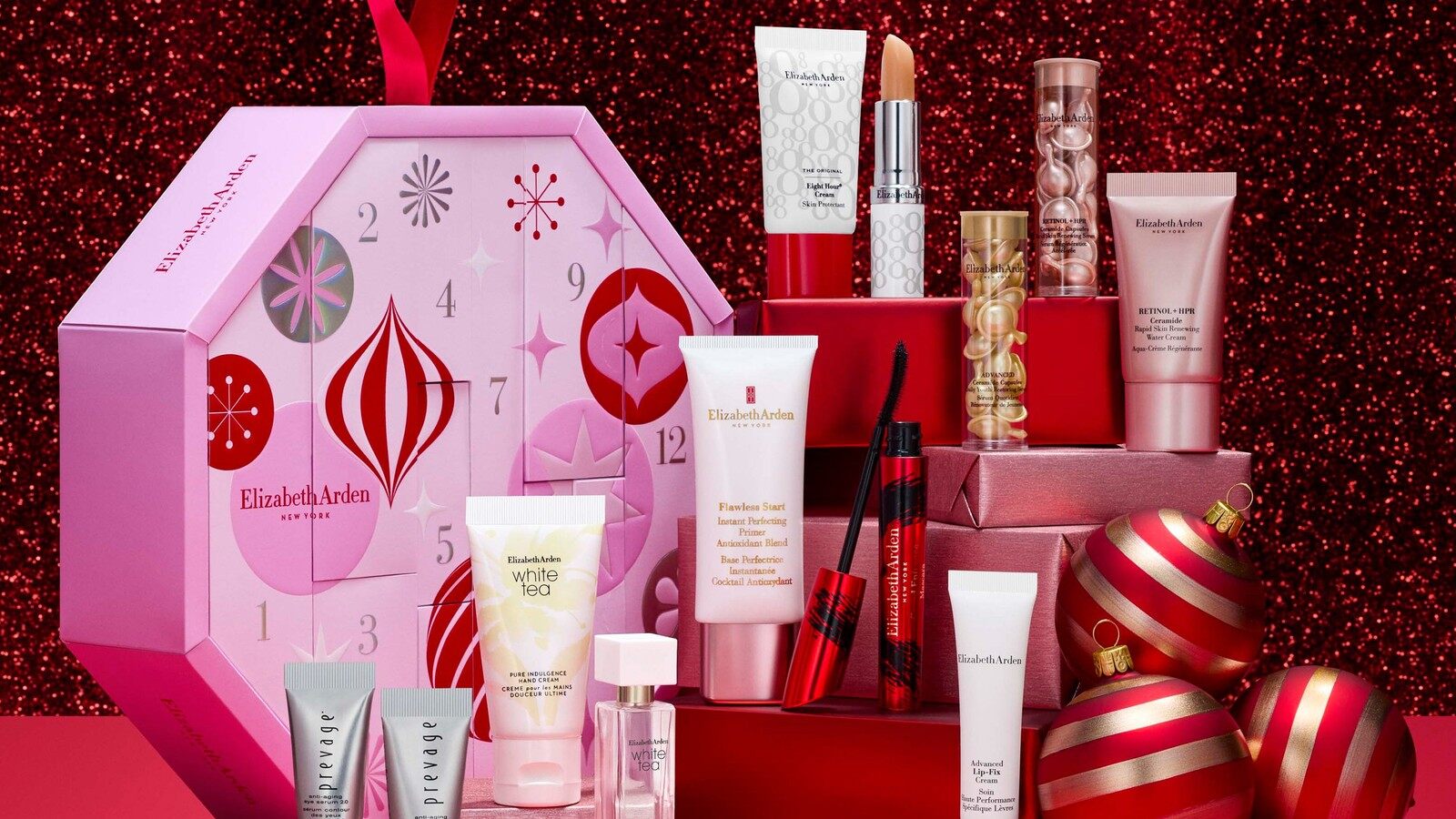 Le calendrier de l’Avent Elizabeth Arden Les 12 Jours Beauté entouré de ses soins et de boules de Noël rouges