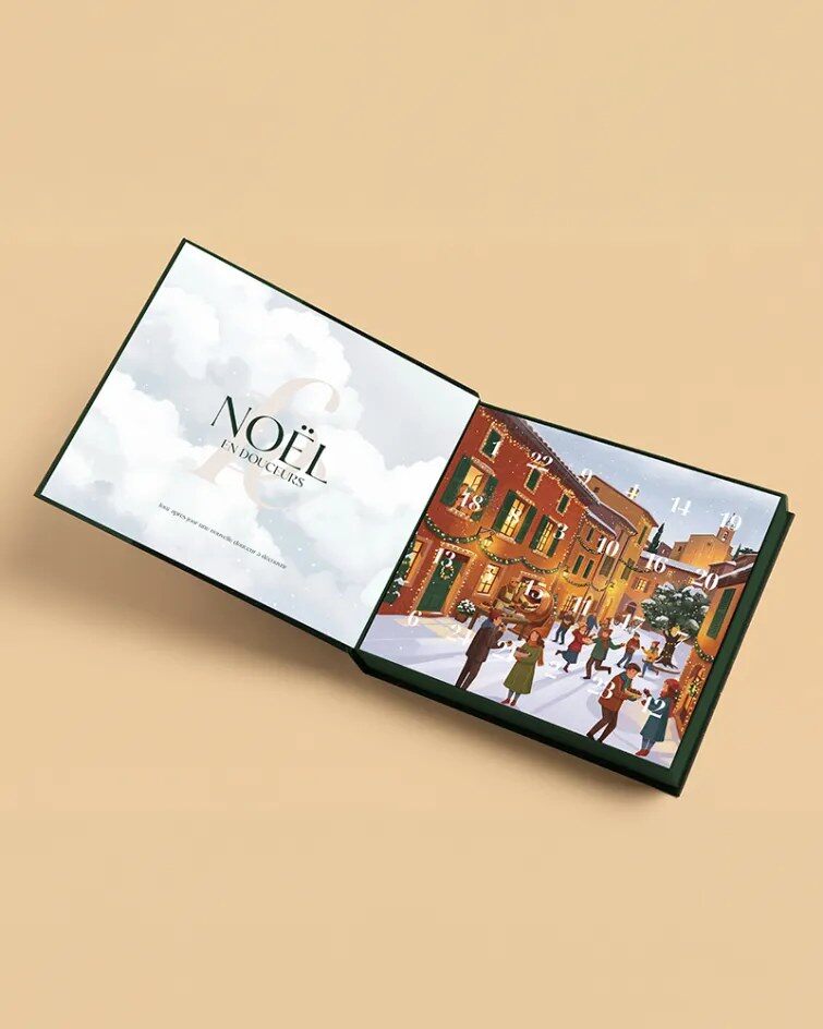 Le coffret du calendrier François Doucet ouvert comme un livre : « Noël en Douceurs » sur la page de gauche, le village provençal avec les fenêtres numérotées sur la page de droite