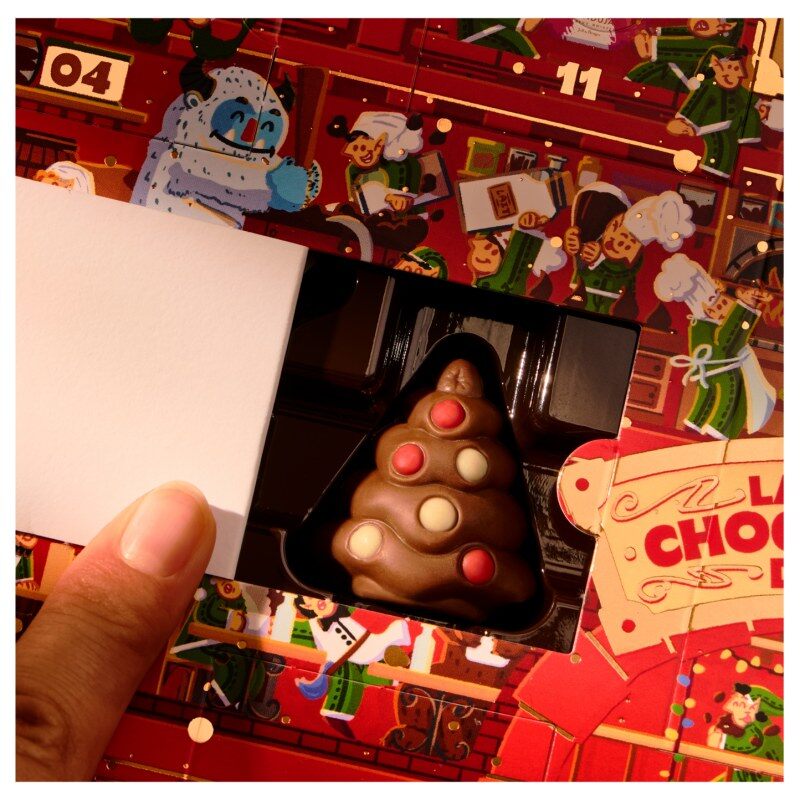 Une case ouverte du calendrier La Chocolaterie du Père Noël, avec un sapin en chocolat