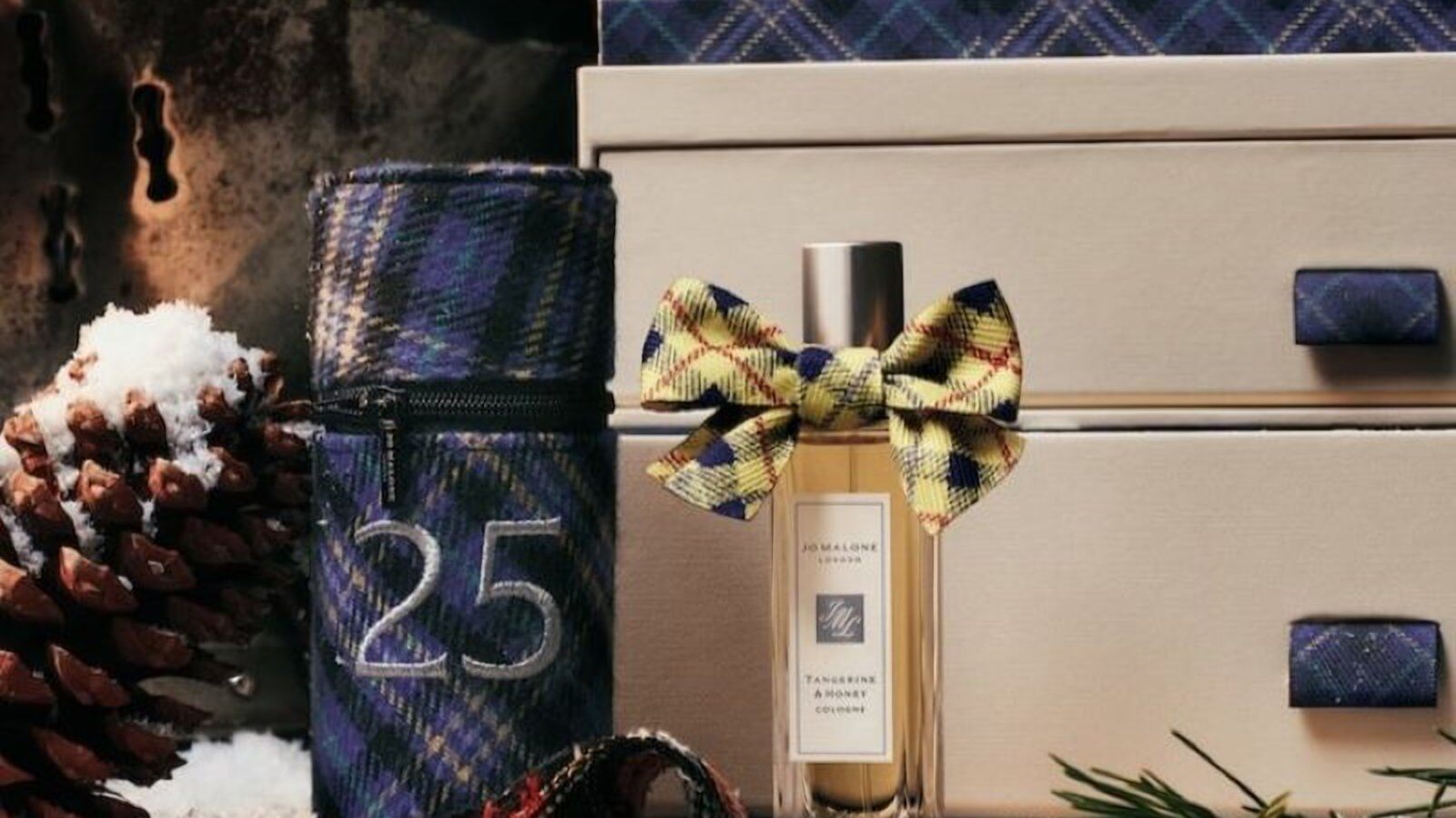 La cologne Tangerine & Honey nouée d’un ruban tartan devant le calendrier de l’Avent Jo Malone London et sa chaussette numéro 25