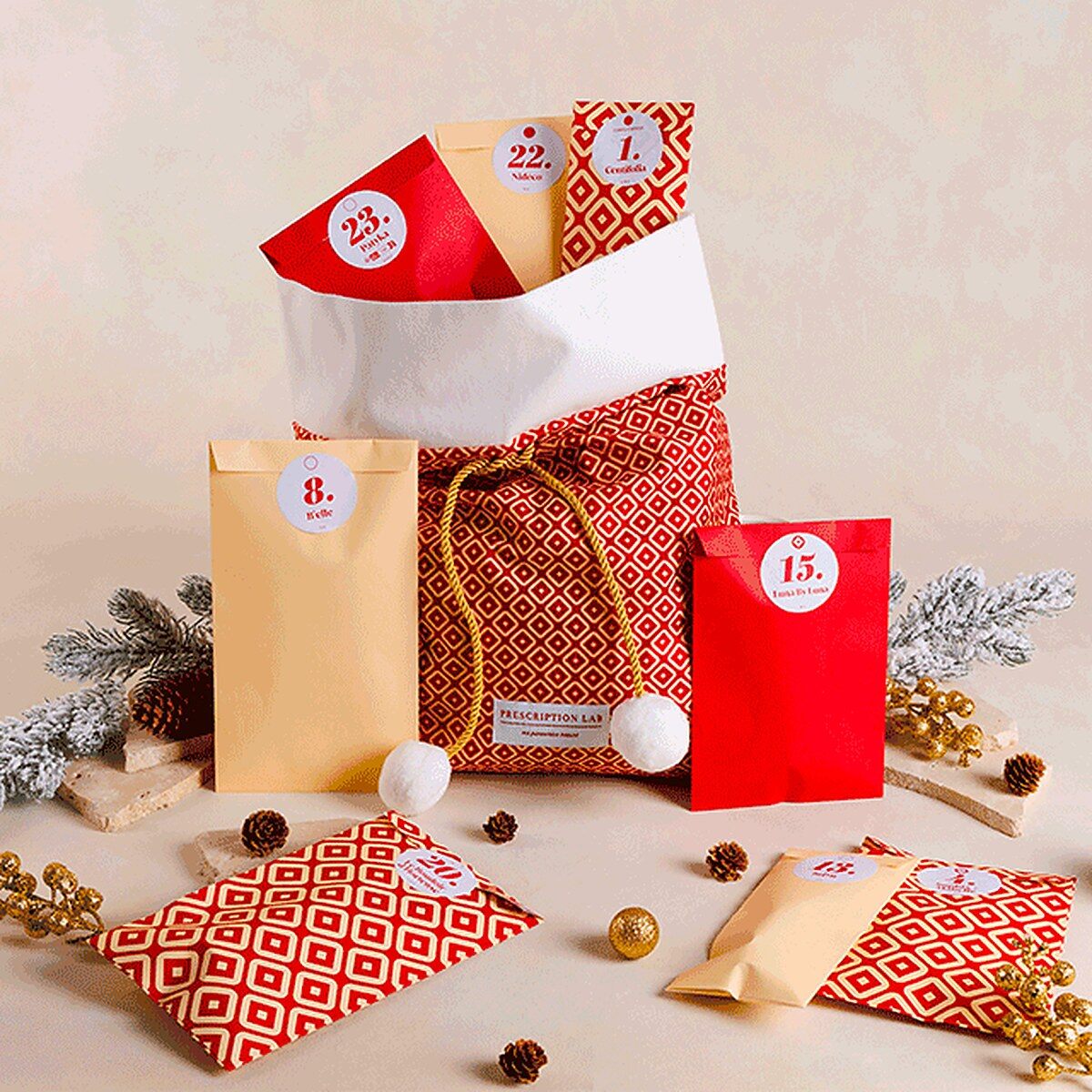 La hotte de Noël rouge à motifs du calendrier de l’Avent Prescription Lab 2026, entourée de produits de beauté et de boules dorées