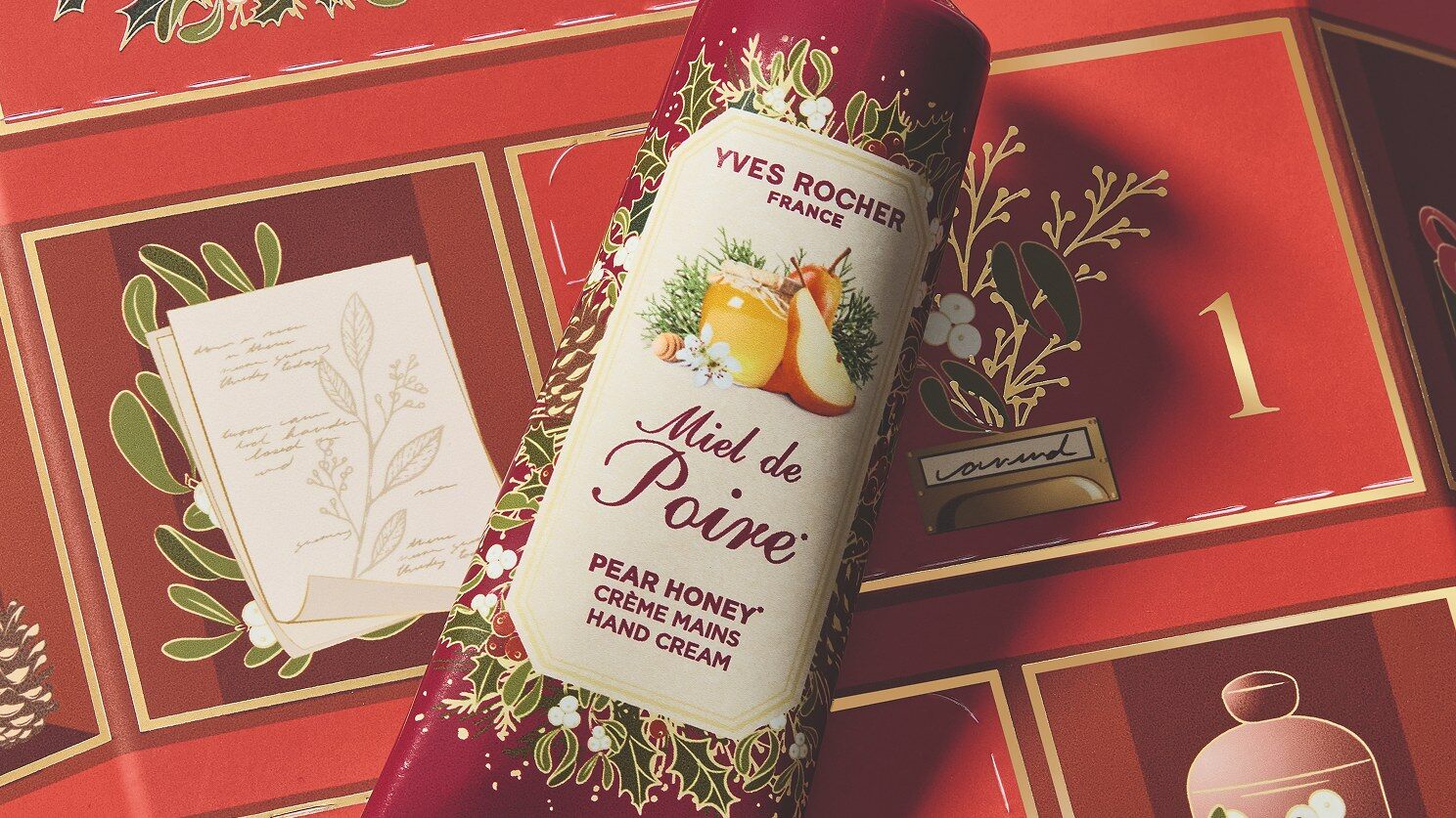 Une crème mains Miel de Poire posée sur le calendrier de l’Avent Yves Rocher 2026 rouge et doré