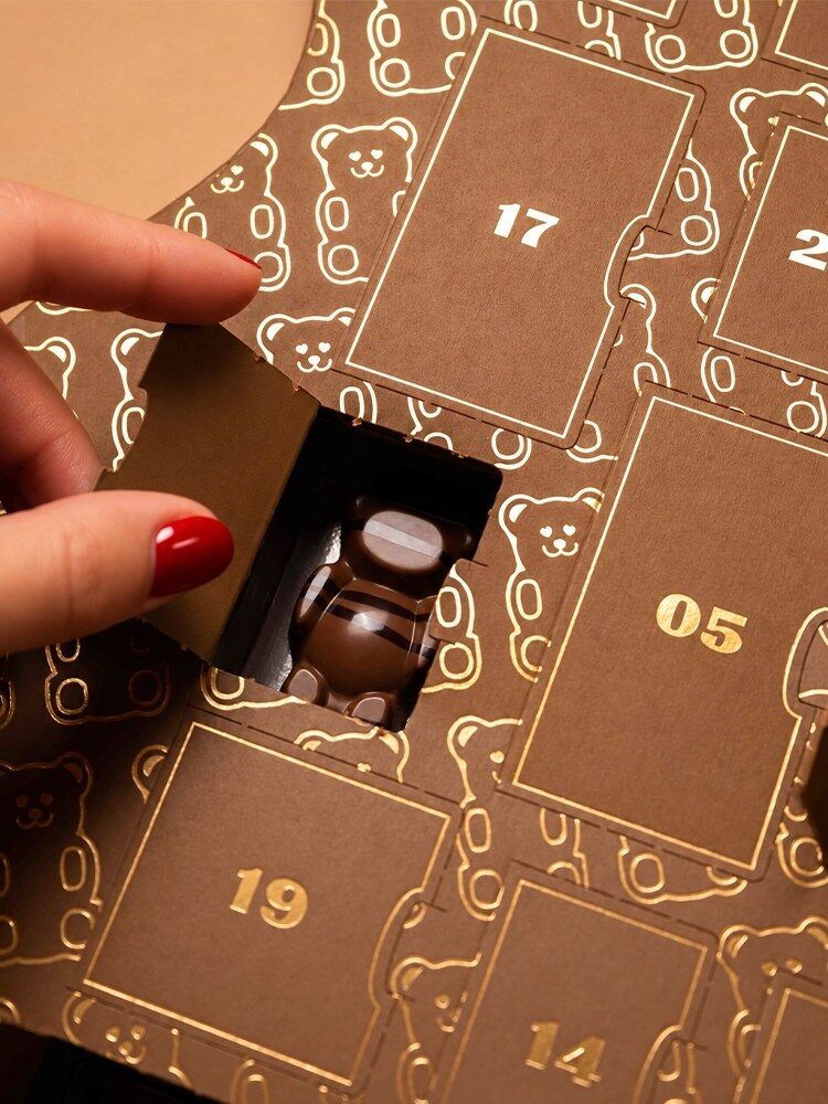 Une main sort un ourson guimauve d’une case du calendrier de l’Avent La Pâtisserie Cyril Lignac