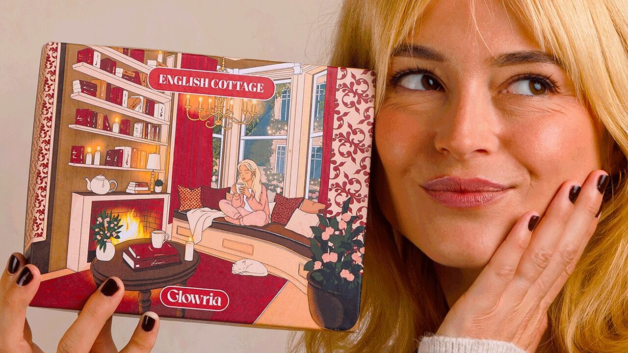 Une jeune femme blonde sourit en tenant la box Glowria English Cottage