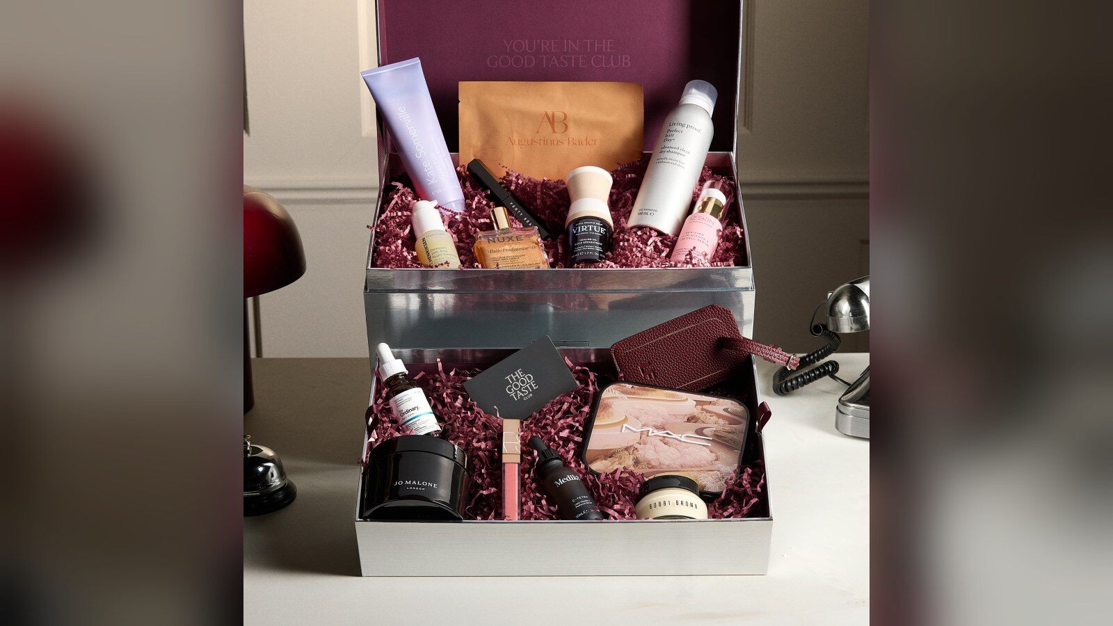 Le Coffret Beauté Lookfantastic ouvert, avec ses produits en taille réelle sur un lit de papier bordeaux