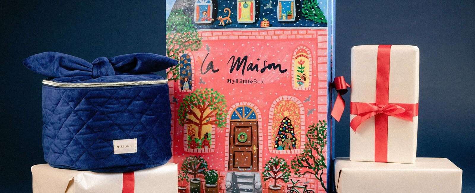 Le Vanity de l’Avent bleu velours et le calendrier illustré La Maison de My Little Box au milieu de paquets cadeaux